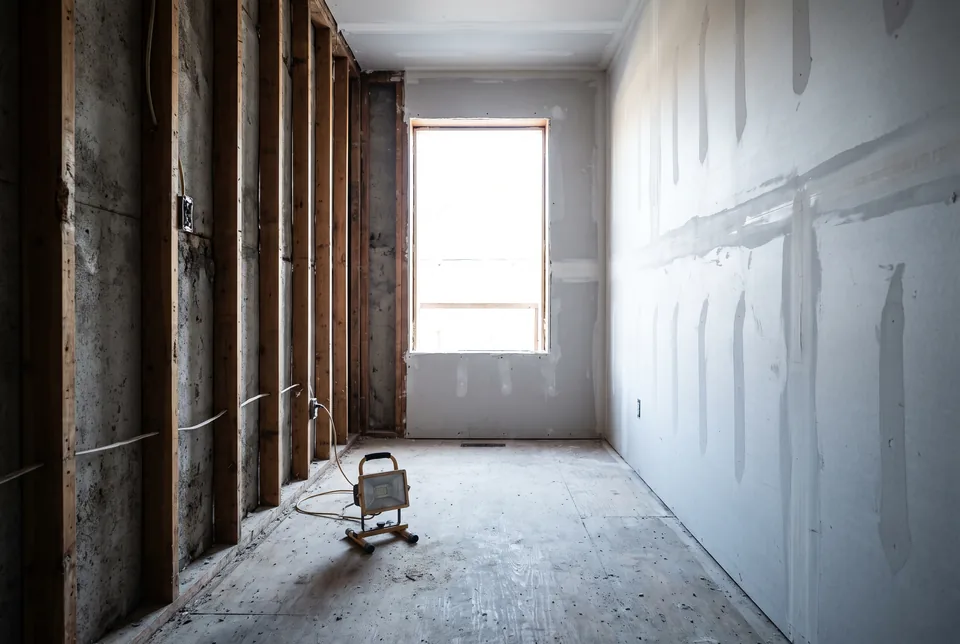 A room stripped to the studs on one side and newly boarded on the other